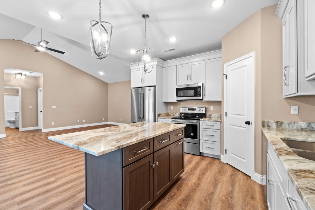 Modern kitchen with island, stainless steel appliances, and granite countertops.